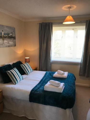 a bedroom with a large bed with towels on it at Arma Short Stays Conifer Drive in Bicester