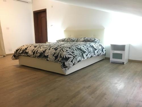 a bedroom with a bed and a wooden floor at Juliet's House in Lettomanoppello