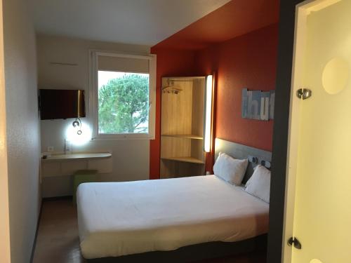 
a hotel room with a bed and a desk at ibis budget Narbonne Est in Narbonne
