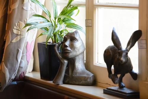 a window sill with a statue of a girl and a plant at The Kings Arms in Sherborne