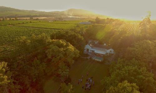 a group of people standing in a field near a house at Rouana Guest Farm in Stellenbosch