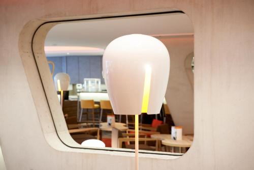 a large white light fixture hanging from a wall at Simm's Hotel - cityhotel next to Metro U3 in Vienna
