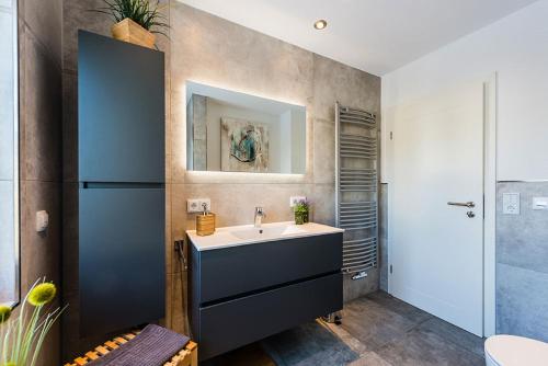 ein Bad mit einem Waschbecken und einem Spiegel in der Unterkunft Ferienwohnung Holl in Bayreuth