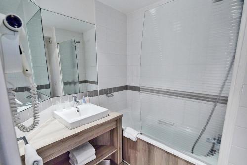 a bathroom with a sink and a shower at Campanile Le Bourget – Airport in Le Bourget