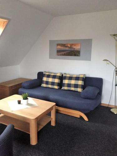 a living room with a blue couch and a table at Hotel Strandräuber in Kalifornien