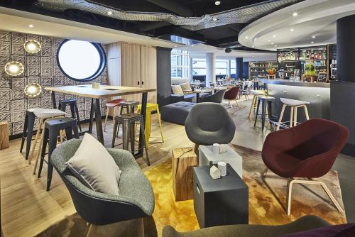 un restaurant avec des chaises et des tables ainsi qu'un bar dans l'établissement Campanile Le Bourget – Airport, au Bourget