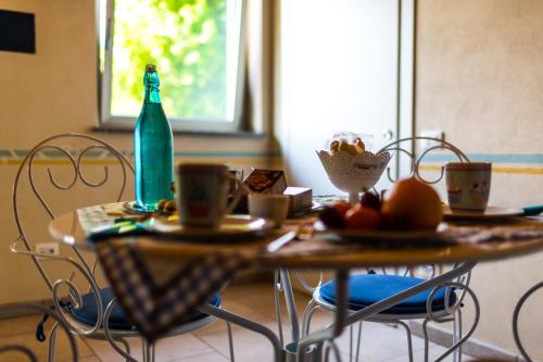 stół z butelką i kubkami w obiekcie B&B Il Rovere w mieście Gattico