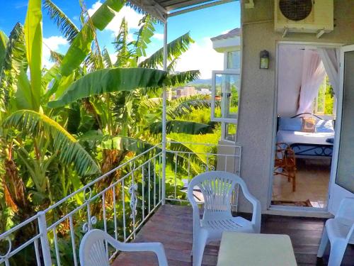a balcony with two chairs and a table and a bed at Surf House in La Gaulette