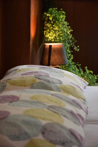 a bed with a pillow and a lamp on it at Guest House Park Žibert in Ljubljana