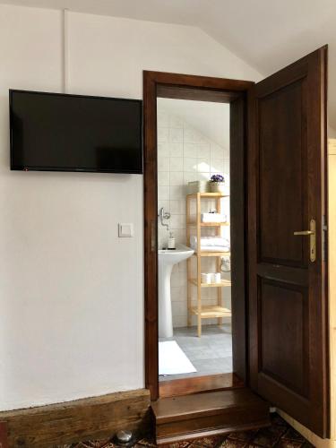 a bathroom with a tv on the wall and a door at Familia in Český Krumlov