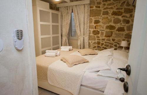 a bedroom with a bed with white sheets and a window at Arheo apartments in Dubrovnik
