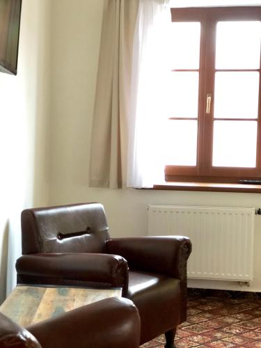 a couch and a chair in a room with a window at Familia in Český Krumlov