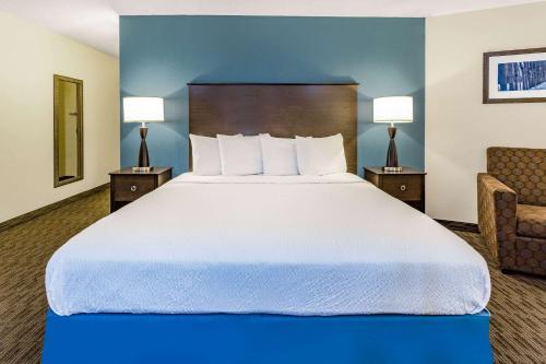 a large bed in a hotel room with two lamps at AmericInn by Wyndham Hotel and Suites Long Lake in Long Lake