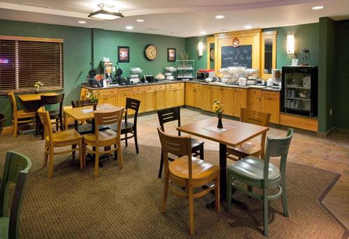 een restaurant met tafels en stoelen en een keuken bij AmericInn by Wyndham Anamosa in Anamosa
