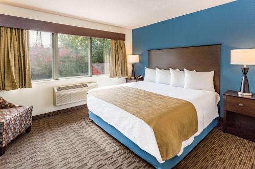 a hotel room with a large bed and a window at AmericInn by Wyndham Hotel and Suites Long Lake in Long Lake