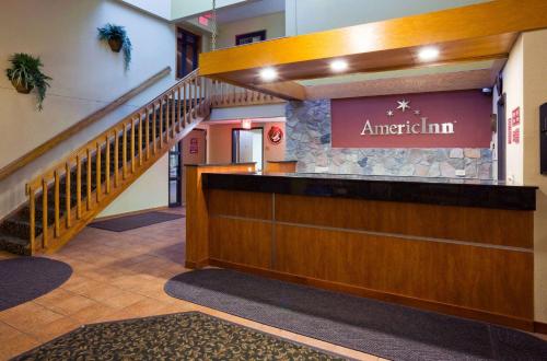 a lobby of an antioch inn with a staircase at AmericInn by Wyndham Fargo West Acres in Fargo