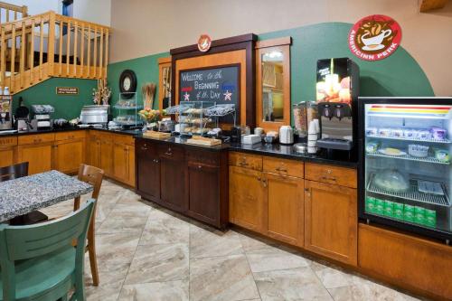 a fast food restaurant with a counter with a food counter at AmericInn by Wyndham Sartell in Sartell