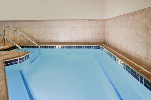 a large swimming pool in a hotel room at AmericInn by Wyndham Osage in Osage