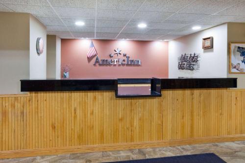 a waiting room with an american sign on the wall at AmericInn by Wyndham Sartell in Sartell