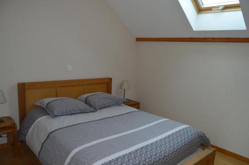 1 dormitorio con cama y ventana en Le Pressoir des 4 Saisons, en Berrwiller
