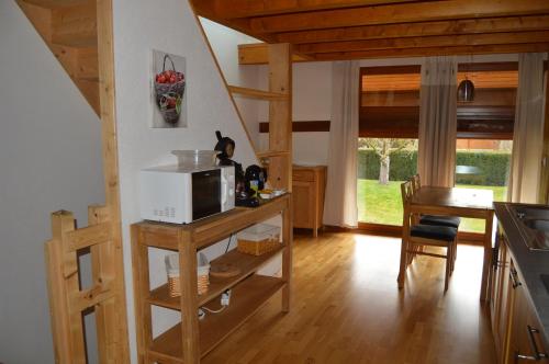 - une cuisine avec un comptoir, un four micro-ondes et une table dans l'établissement Le Pressoir des 4 Saisons, à Berrwiller