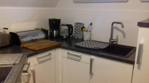 a kitchen with a sink and a counter top at Das Rosenhaus in Utersum