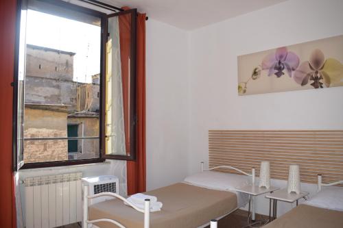 ローマにあるPaolina Roomsのベッド2台と窓のある病室です。