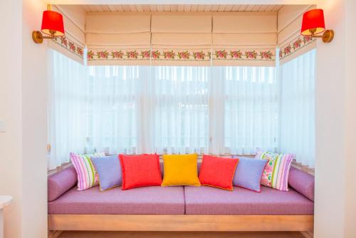 a purple couch with colorful pillows in front of a window at Villa TN - Fethiye in Fethiye