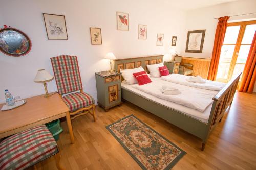 a bedroom with a bed and a table and a chair at Alpengasthof Madlbauer in Bad Reichenhall