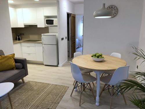 a kitchen and living room with a table and chairs at Apartaments La Palmera, Terrace & Pool in Sant Martí d'Empúries