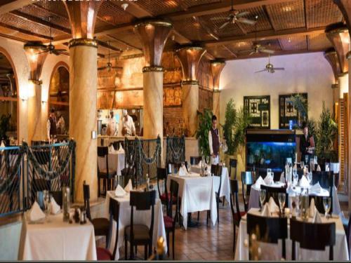 a restaurant with white tables and chairs in a room at Concorde El Salam Cairo Hotel & Casino in Cairo