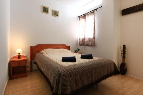 アレシーフェにあるHoliday Apartment C Lanzaroteのベッドルーム1室(ベッド1台、テーブル、窓付)