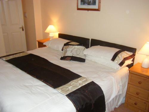 a bedroom with a large white bed with black and white pillows at Ashfield B&B in Kenmare