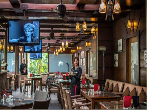 a woman standing in a restaurant with a tv at Concorde El Salam Cairo Hotel & Casino in Cairo
