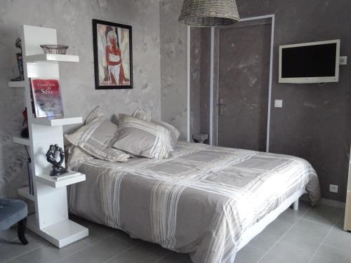 - une chambre avec un lit blanc et une télévision dans l'établissement rêverie, à Balaruc-les-Bains