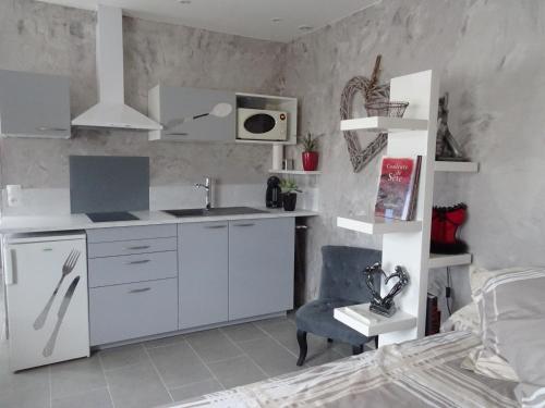 - une cuisine avec un évier et un bureau dans la chambre dans l'établissement rêverie, à Balaruc-les-Bains