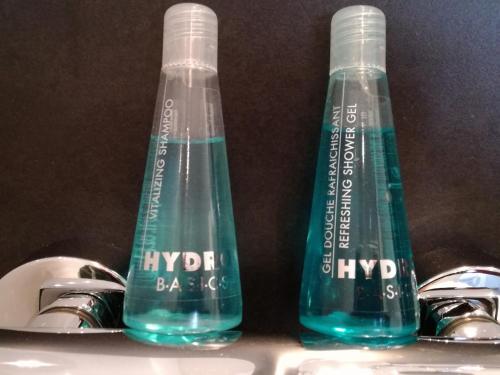 two bottles of water sitting on top of a sink at Zimmer zum Hof in Herdecke