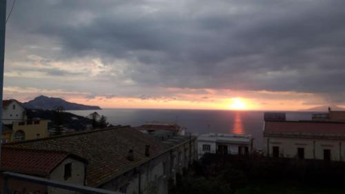 a sunset over the ocean with houses and buildings at Sunset rooms in Massa Lubrense