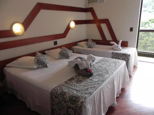 two beds in a room with stuffed animals on them at Serra Negra Paladium Hotel in Serra Negra