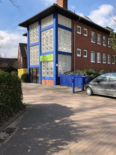 a building with a car parked in front of it at BoardingHouse Quickborn in Quickborn