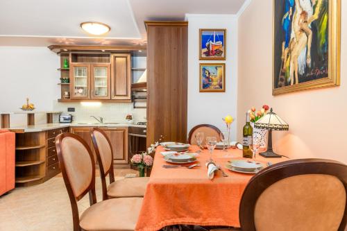 a dining room with a table and a kitchen at Apartment Noa Opatija in Opatija