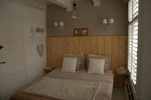 a bedroom with a bed with a wooden wall at De Slapende Leeuw in Middelburg