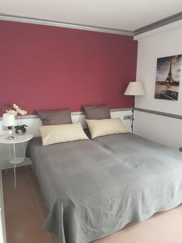 a bedroom with a large bed and a red wall at Sun and Beach Spain 1B in Nerja