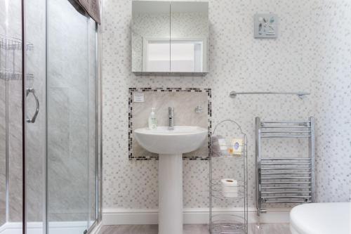 uma casa de banho com um lavatório e um chuveiro em The Beechcliffe Hotel - Over 35's Only em Blackpool