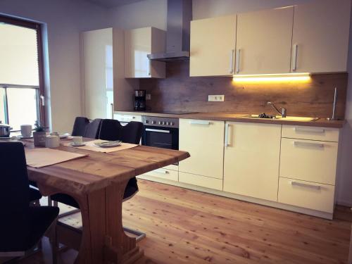 a kitchen with a wooden table and white cabinets at Bergblick in Grossarl