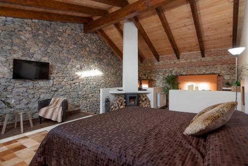 a bedroom with a bed and a stone wall at Estudio Sonido y Jacuzzi in Santander