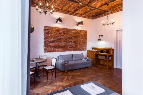 salon z kanapą i ceglaną ścianą w obiekcie Lovenovsky Apartments w Krakowie