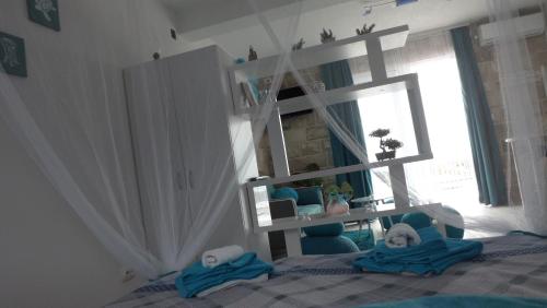 a bedroom with a bed with blue chairs and a mirror at Luštica Apartments in Lustica