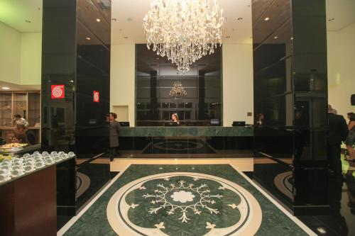 a lobby of a hotel with a chandelier at Porto Feliz Executive Hotel in Pôrto Feliz