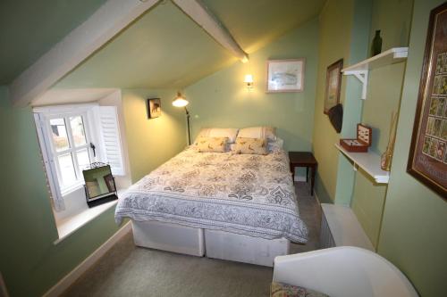 ein Schlafzimmer mit einem Bett in einem grünen Zimmer in der Unterkunft Cosy Crickhowell Cottage in Crickhowell
